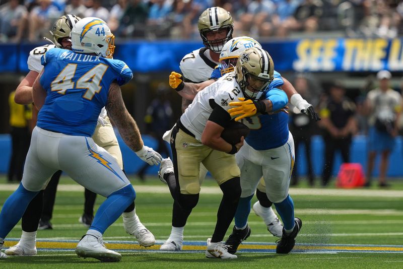 Aug 10, 2025; Inglewood, California, USA; New Orleans Saints quarterback Spencer Rattler (2) is sacked by Los Angeles Chargers linebacker Caleb Murphy (50) during the second quarter at SoFi Stadium. Mandatory Credit: Jon Endow-Imagn Images