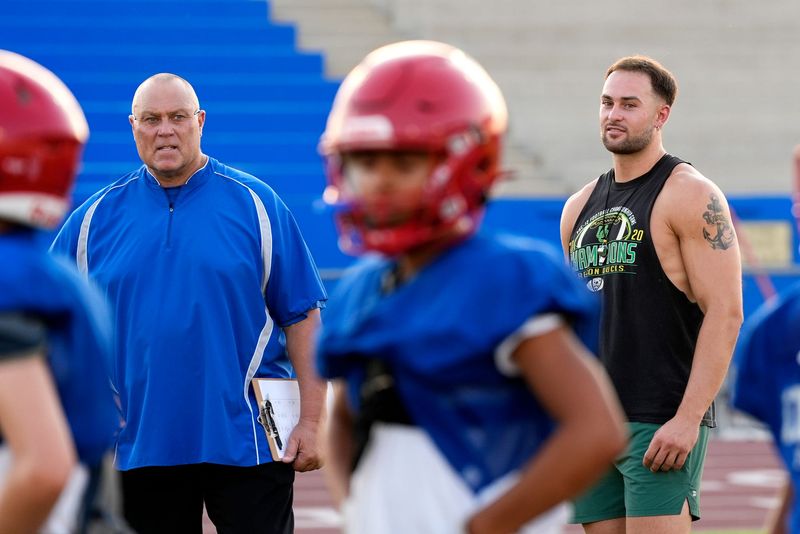 Ron Shipley, left, and his son, Jake Shipley, coach football together during practice at Indio High School in Indio, Calif., on August 13, 2025.
