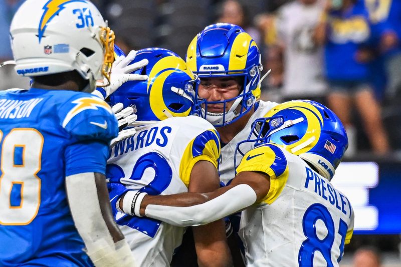 Aug 16, 2025; Inglewood, California, USA; Los Angeles Rams wide receiver Tru Edwards (82) hugs tight end Mark Redman (83) and wide receiver Brennan Presley (81) after scoring a touchdown against the Los Angeles Chargers during the fourth quarter at SoFi Stadium. Mandatory Credit: Jonathan Hui-Imagn Images