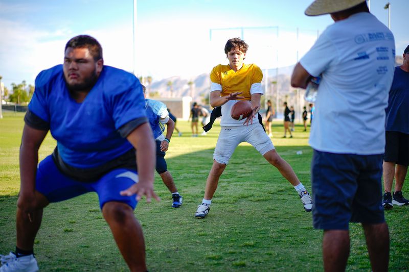 Cathedral City High School quarterback Jaden Tapia, center, takes snaps during practice in Cathedral City, Calif., August 19, 2025.