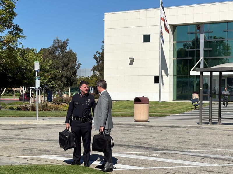 Port Hueneme Police Chief Michael Federico and his attorney, Travis Mackprang, talk outside of the courthouse after an Aug. 21 hearing in a lawsuit brought against Federico by Port Hueneme City Council member Laura Hernandez.