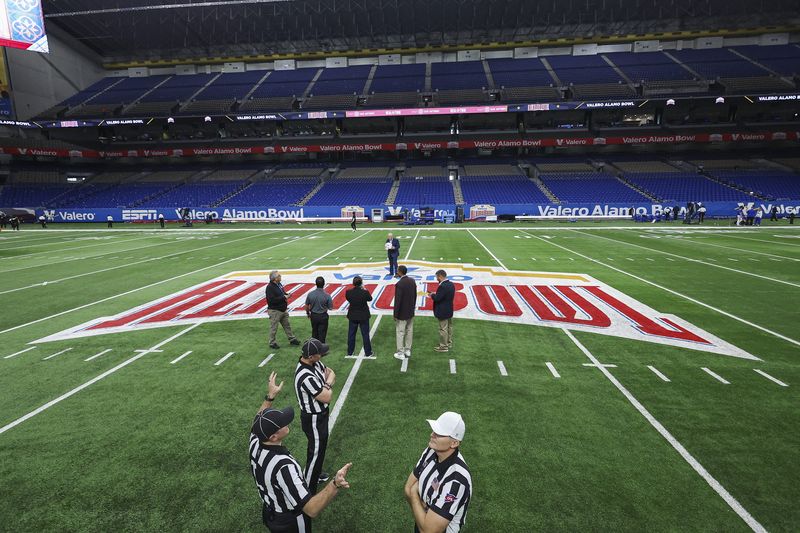Dec 28, 2024; San Antonio, TX, USA; Officials talk on the field at Alamodome before the game between the Colorado Buffaloes and the Brigham Young Cougars. Mandatory Credit: Troy Taormina-Imagn Images