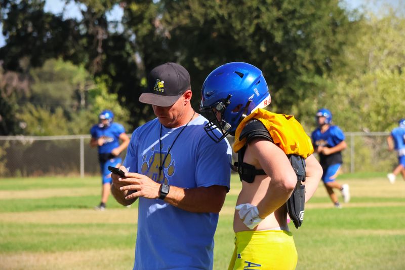 Anderson head football coach PJ O'Connell works with receiver Ocean Knight in practice on Aug. 19, 2025.