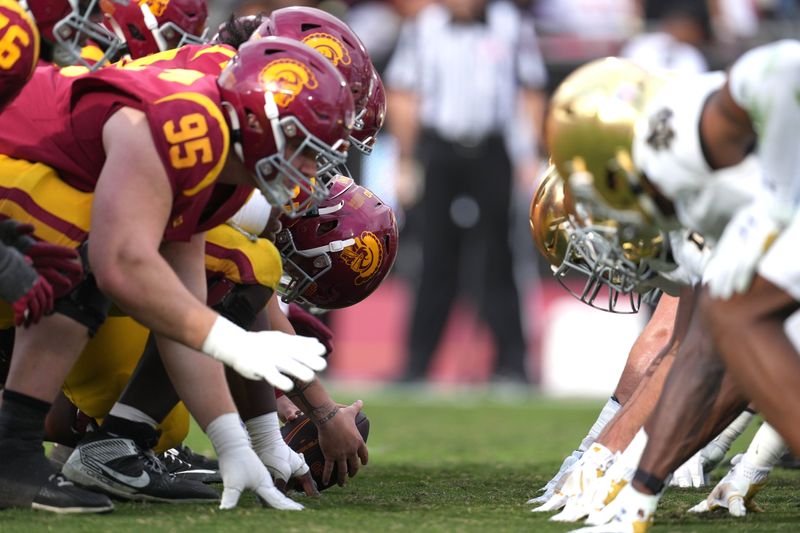 Nov 30, 2024; Los Angeles, California, USA; A general view of Southern California Trojans and Notre Dame Fighting Irish helmets at the line of scrimmage in the first half at United Airlines Field at Los Angeles Memorial Coliseum. Mandatory Credit: Kirby Lee-Imagn Images