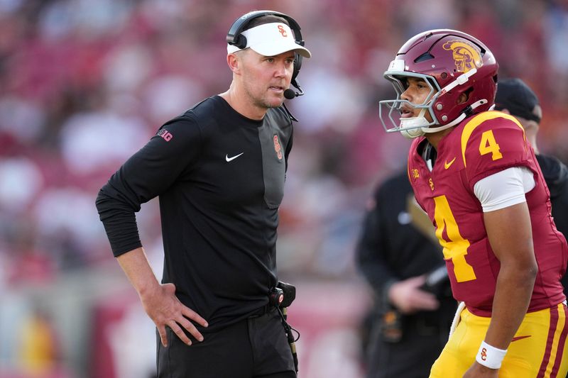 Aug 30, 2025; Los Angeles, California, USA; Southern California Trojans head coach Lincoln Riley talks with Southern California Trojans quarterback Husan Longstreet (4) in the second half against the Missouri State Bears at United Airlines Field at Los Angeles Memorial Coliseum. Mandatory Credit: Kirby Lee-Imagn Images
