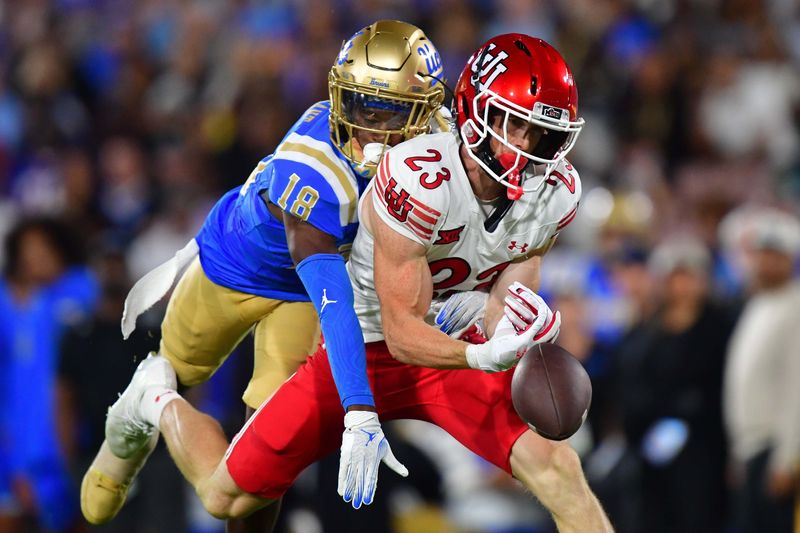 Aug 30, 2025; Pasadena, California, USA; Utah Utes safety Jackson Bennee (23) on offense misses catching a pass against the defense of UCLA Bruins defensive back Jadyn Marshall (18) during the first half at Rose Bowl. Mandatory Credit: Gary A. Vasquez-Imagn Images