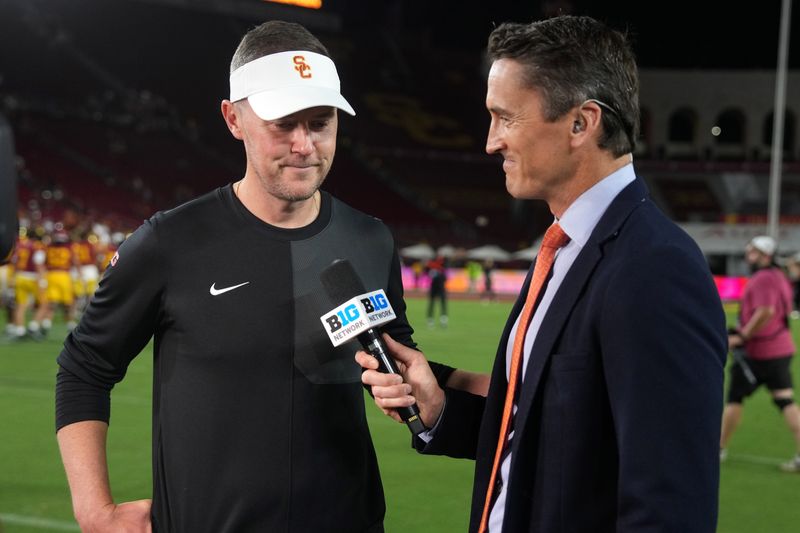 Aug 30, 2025; Los Angeles, California, USA; Big Ten Network reporter Rhett Lewis (right) interviews Southern California Trojans head coach Lincoln Riley after the game against the Missouri State Bears at United Airlines Field at Los Angeles Memorial Coliseum. Mandatory Credit: Kirby Lee-Imagn Images