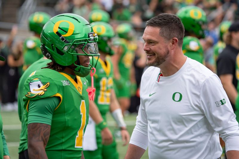 Oregon head coach Dan Lanning, right, talks with Oregon wide receiver Dakorien Moore during warmups as the Oregon Ducks host the Oklahoma State Cowboys on Sept. 6, 2025, at Autzen Stadium in Eugene, Oregon.
