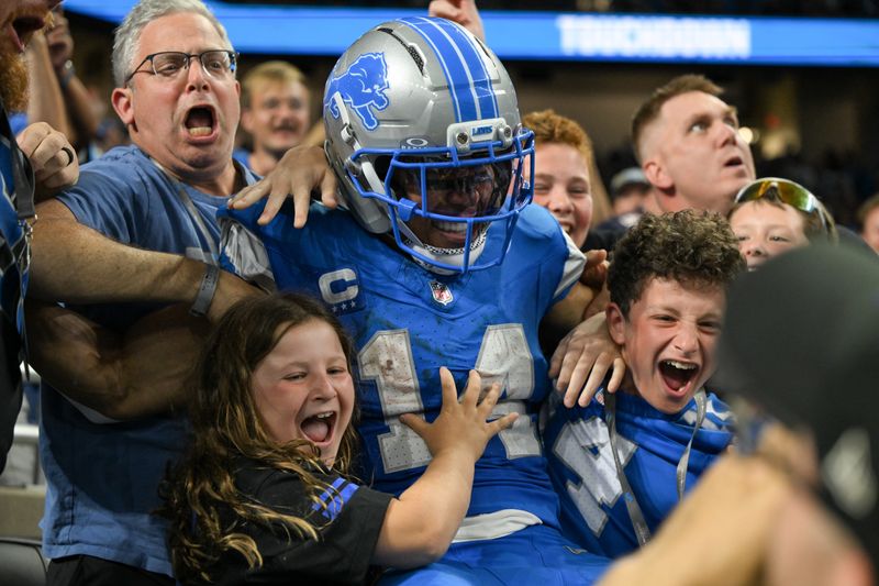 Sep 14, 2025; Detroit, Michigan, USA; Detroit Lions wide receiver Amon-Ra St. Brown (14) leaps into the crowd after a touchdown against the Chicago Bears during the fourth quarter of the game at Ford Field. Mandatory Credit: Lon Horwedel-Imagn Images