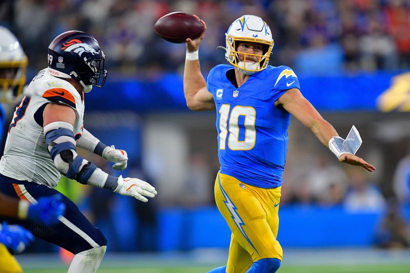 Dec 19, 2024; Inglewood, California, USA; Los Angeles Chargers quarterback Justin Herbert (10) throws as Denver Broncos defensive end Zach Allen (99) moves in during the second half at SoFi Stadium. Mandatory Credit: Gary A. Vasquez-Imagn Images