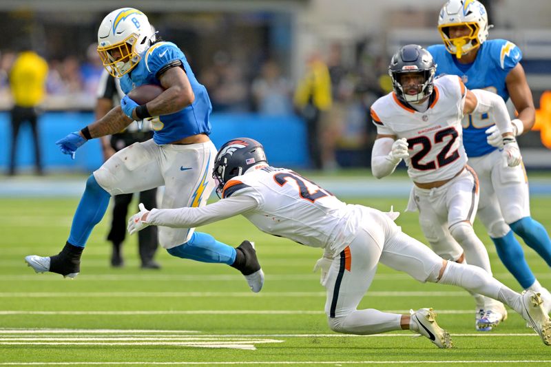 Sep 21, 2025; Inglewood, California, USA; Los Angeles Chargers running back Omarion Hampton (8) is tripped up by Denver Broncos cornerback Riley Moss (21) after a first down in the fourth quarter at SoFi Stadium. Mandatory Credit: Jayne Kamin-Oncea-Imagn Images