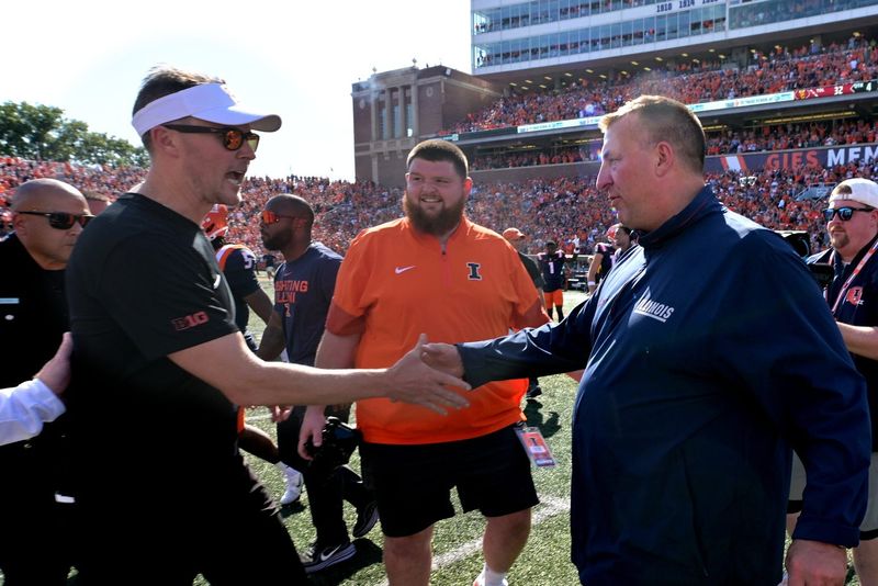 Sep 27, 2025; Champaign, Illinois, USA; Illinois Fighting Illini head coach Bret Bielema, right, and Southern California Trojans head coach Lincoln Riley shake hands after the 34-32 Illini win at Memorial Stadium. Mandatory Credit: Ron Johnson-Imagn Images