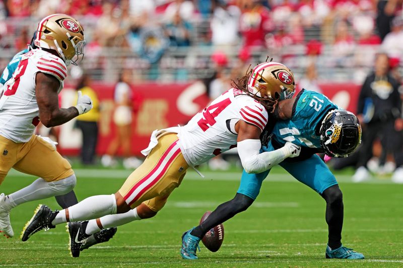 Sep 28, 2025; Santa Clara, California, USA; Jacksonville Jaguars wide receiver Travis Hunter (12) runs the ball against San Francisco 49ers linebacker Fred Warner (54) during the second half at Levi's Stadium. Mandatory Credit: Darren Yamashita-Imagn Images