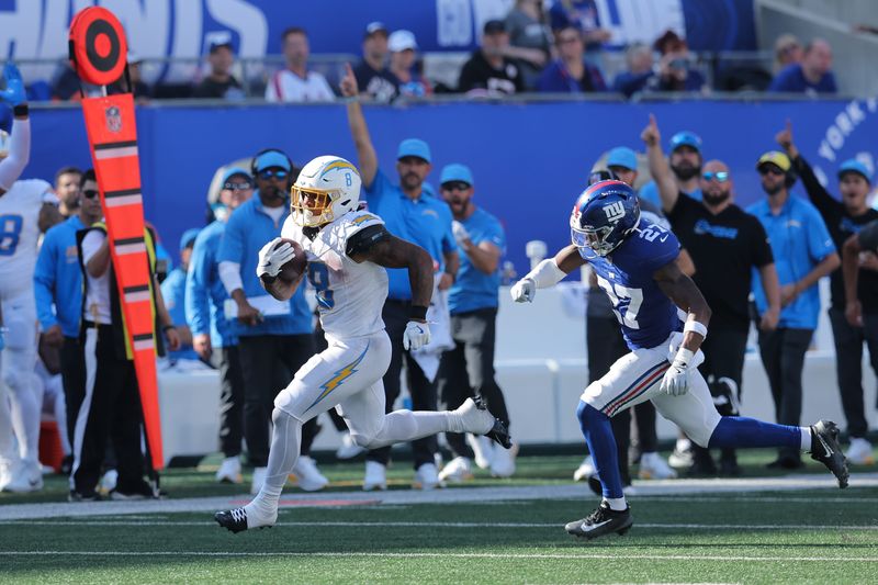 Sep 28, 2025; East Rutherford, New Jersey, USA; Los Angeles Chargers running back Omarion Hampton (8) runs for a touchdown as New York Giants safety Tyler Nubin (27) defends during the third quarter at MetLife Stadium. Mandatory Credit: Brad Penner-Imagn Images