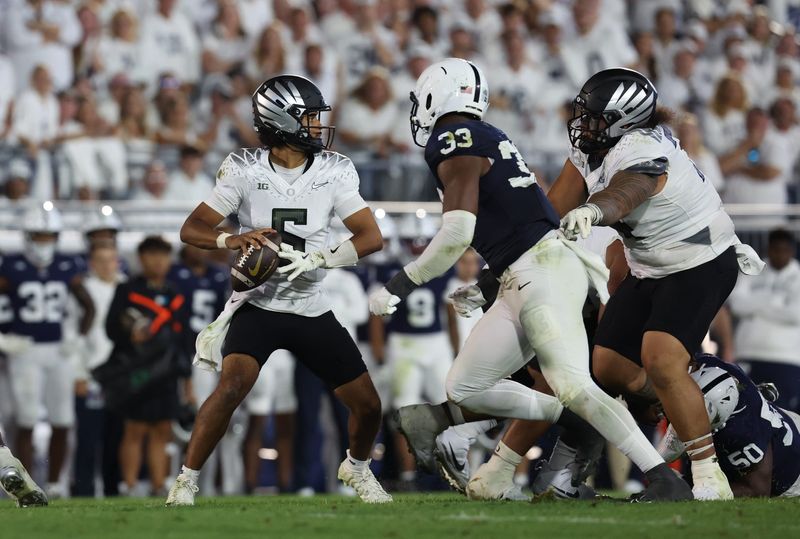 Sep 27, 2025; University Park, Pennsylvania, USA; Oregon Ducks quarterback Dante Moore (5) throws during the second quarter against the Penn State Nittany Lions at Beaver Stadium. Mandatory Credit: Matthew O'Haren-Imagn Images