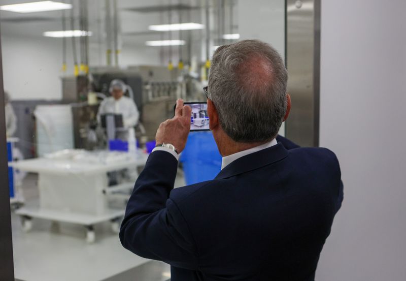 Thousand Oaks Mayor David Newman takes a photo of workers inside a lab during a tour of Japanese pharmaceutical company Takeda's recently expanded Thousand Oaks facility Oct. 1.