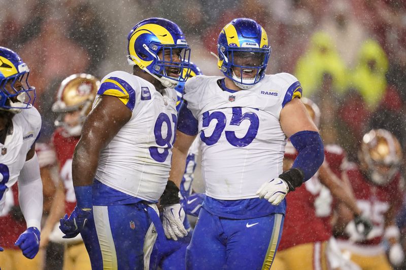 Dec 12, 2024; Santa Clara, California, USA; Los Angeles Rams defensive tackle Kobie Turner (91) is congratulated by defensive tackle Braden Fiske (55) after recording a sack against the San Francisco 49ers in the second quarter at Levi's Stadium. Mandatory Credit: Cary Edmondson-Imagn Images