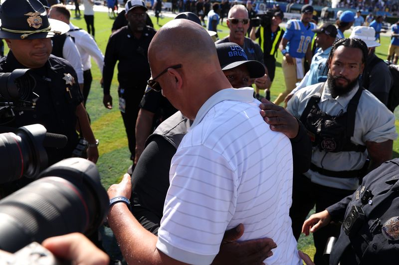 Oct 4, 2025; Pasadena, California, USA; UCLA Bruins interim head coach Tim Skipper (black cap) hugs Penn State Nittany Lions head coach James Franklin after defeating the Penn State 42-37 at Rose Bowl. Mandatory Credit: Kiyoshi Mio-Imagn Images