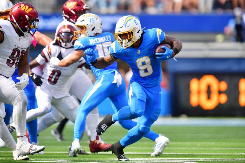 Oct 5, 2025; Inglewood, California, USA; Los Angeles Chargers running back Omarion Hampton (8) runs against Washington Commanders defensive tackle Jer'Zhan Newton (95) in the first half at SoFi Stadium. Mandatory Credit: Gary A. Vasquez-Imagn Images
