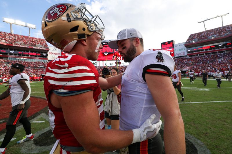 Nov 10, 2024; Tampa, Florida, USA; San Francisco 49ers running back Christian McCaffrey (23) greets Tampa Bay Buccaneers quarterback Baker Mayfield (6) after a game at Raymond James Stadium. Mandatory Credit: Nathan Ray Seebeck-Imagn Images