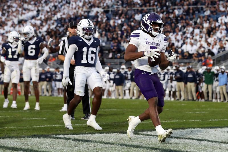 Oct 11, 2025; University Park, Pennsylvania, USA; Northwestern Wildcats running back Caleb Komolafe (5) runs the ball into the end zone for a touchdown during the fourth quarter against the Penn State Nittany Lions at Beaver Stadium. Mandatory Credit: Matthew O'Haren-Imagn Images