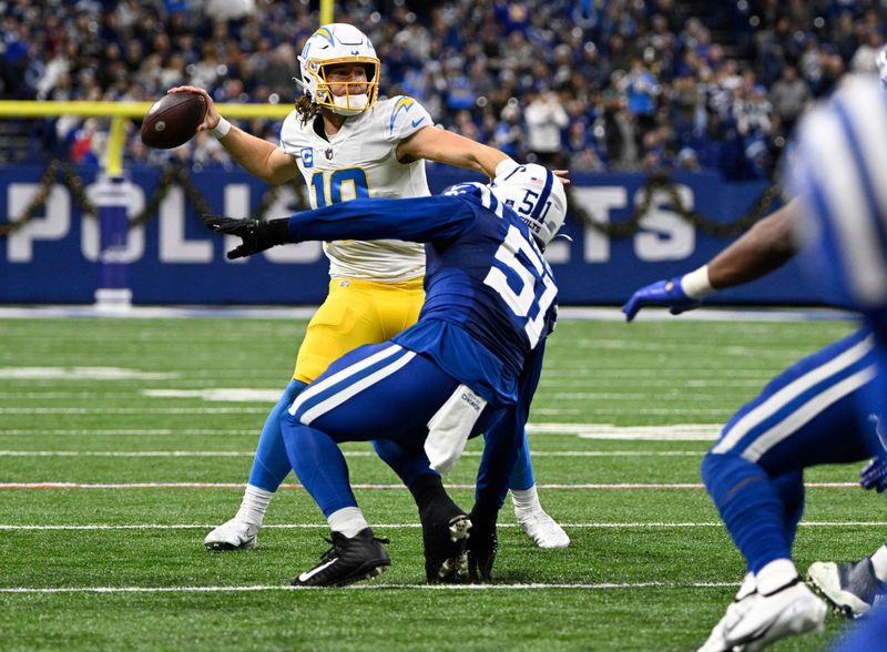 Indianapolis, Indiana, USA; Los Angeles Chargers quarterback Justin Herbert (10) throws a ball before being tackled by Indianapolis Colts defensive end Kwity Paye (51) during the second half at Lucas Oil Stadium. Mandatory Credit: Marc Lebryk-USA TODAY Sports