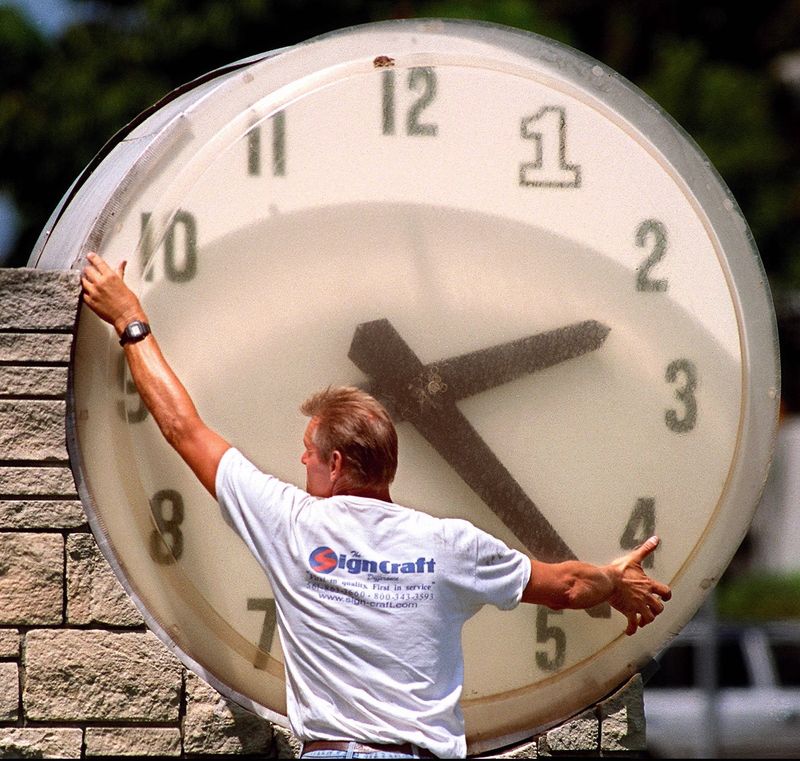 Joe Roskey of Sign Craft, of Riviera Beach, Fla. works on the outdoor clock at the First Federal Savings and Loans, at the corner of Olive Avenue and Southern Blvd in this photo circa April 1999.