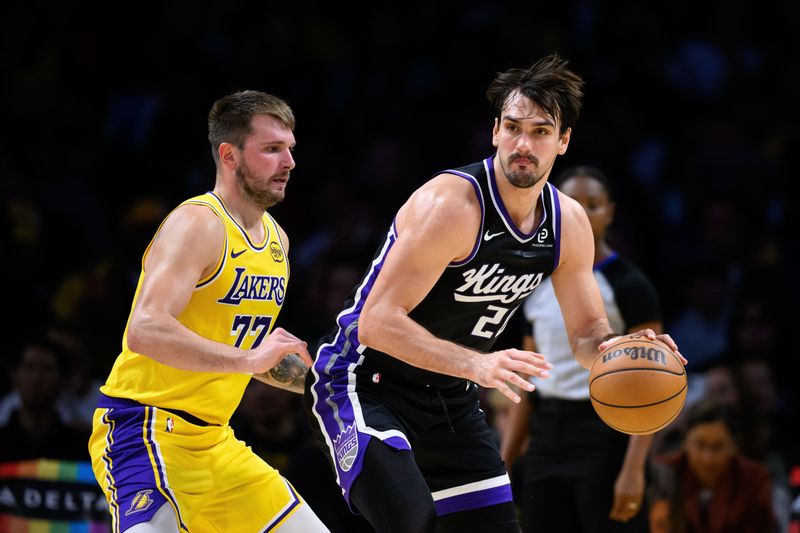 Oct 17, 2025; Los Angeles, California, USA; Sacramento Kings forward Dario Šarić (20) looks to pass while under pressure from Los Angeles Lakers guard Luka Doncic (77) during the second half at Crypto.com Arena. Mandatory Credit: William Liang-Imagn Images