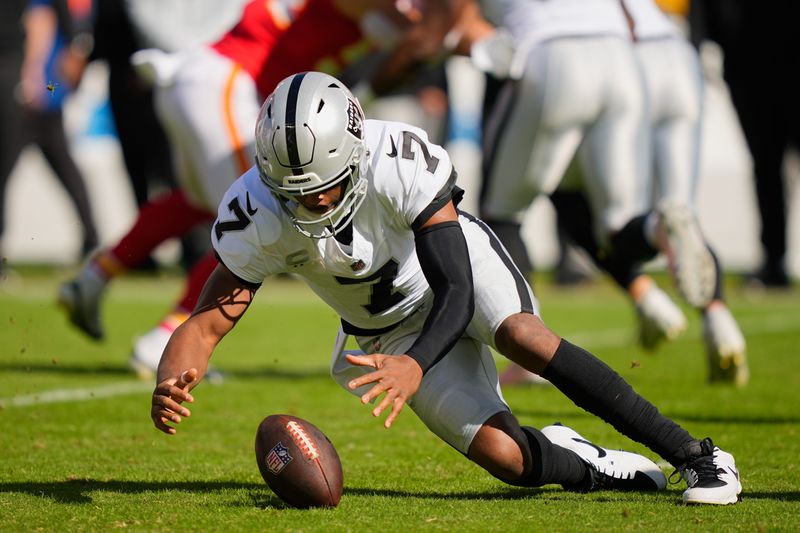 Las Vegas Raiders quarterback Geno Smith recovers a fumble.