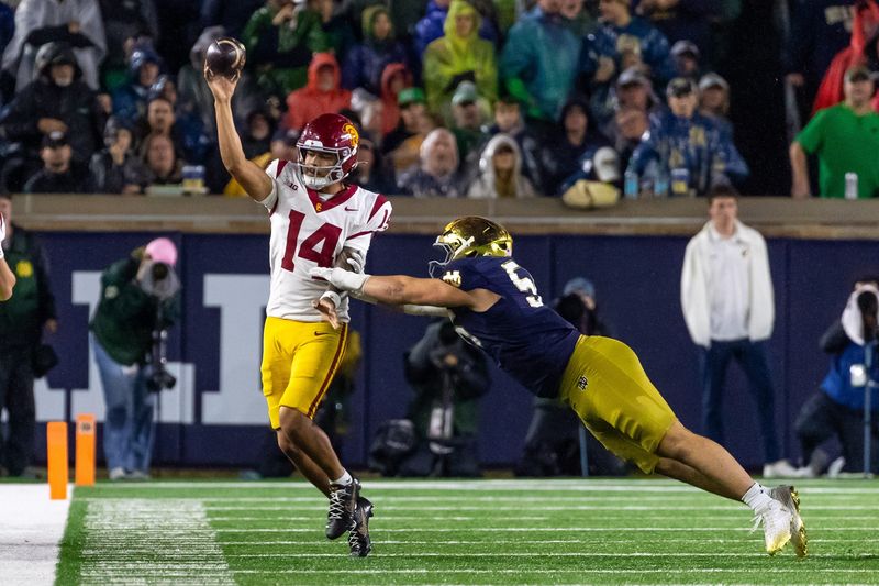 Oct 18, 2025; South Bend, Indiana, USA; Southern California Trojans quarterback Jayden Maiava (14) passes the ball under pressure by Notre Dame Fighting Irish defensive tackle Elijah Hughes (56) during the second half at Notre Dame Stadium. Mandatory Credit: Michael Caterina-Imagn Images