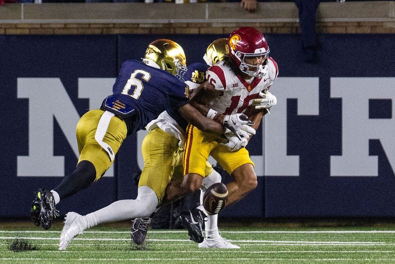 Oct 18, 2025; South Bend, Indiana, USA; Southern California Trojans wide receiver Tanook Hines (16) attempts to catch the ball while Notre Dame Fighting Irish cornerback Christian Gray (6) defends in the first half at Notre Dame Stadium. Mandatory Credit: Trevor Ruszkowski-Imagn Images