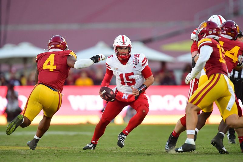 Nov 16, 2024; Los Angeles, California, USA; Nebraska Cornhuskers quarterback Dylan Raiola (15) drops back to pass as Southern California Trojans linebacker Easton Mascarenas-Arnold (4) moves in during the second half at the Los Angeles Memorial Coliseum. Mandatory Credit: Gary A. Vasquez-Imagn Images