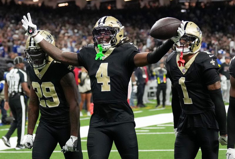 Oct 5, 2025; New Orleans, Louisiana, USA; New Orleans Saints cornerback Quincy Riley (29), New Orleans Saints cornerback Kool-Aid McKinstry (4) and New Orleans Saints cornerback Alontae Taylor (1) celebrate after an interception against the New York Giants during the fourth quarter at Caesars Superdome. Mandatory Credit: Matthew Hinton-Imagn Images