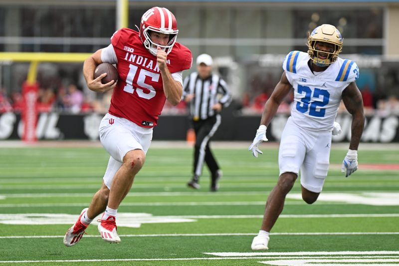 Oct 25, 2025; Bloomington, Indiana, USA; Indiana Hoosiers quarterback Fernando Mendoza (15) runs the ball against UCLA Bruins linebacker Isaiah Chisom (32) during the second half at Memorial Stadium. Mandatory Credit: Robert Goddin-Imagn Images