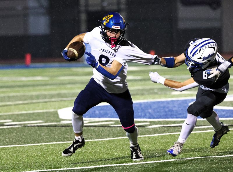 Anderson’s Jagger Johnson, left, tries to get past U-Prep’s Jackson Kersten in their game on a rainy night in Redding. U-Prep defeated Anderson 32-6 on Friday, Oct. 24, 2025.
