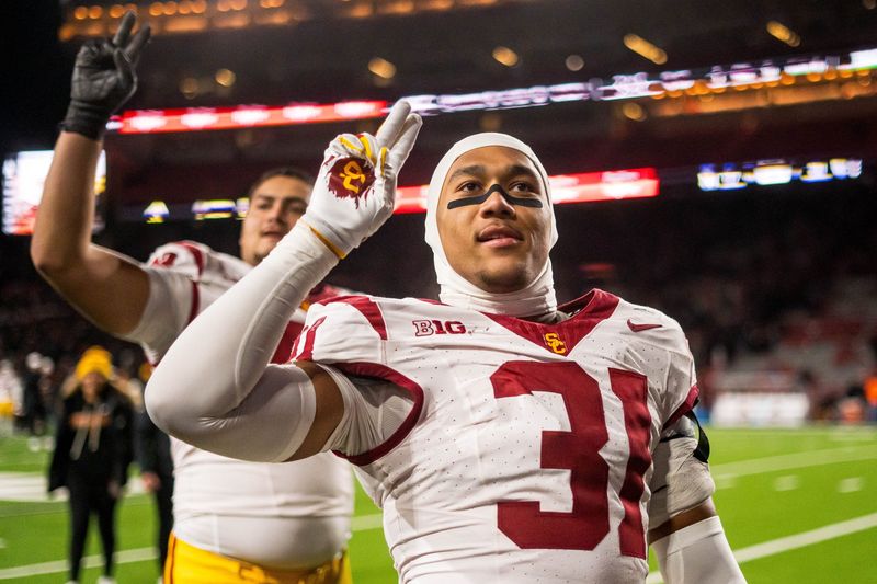 Nov 1, 2025; Lincoln, Nebraska, USA; Southern California Trojans linebacker Jadyn Walker (31) and offensive lineman Elijah Paige (72) hold up a â€œVâ€ to fans after defeating the Nebraska Cornhuskers at Memorial Stadium. Mandatory Credit: Dylan Widger-Imagn Images