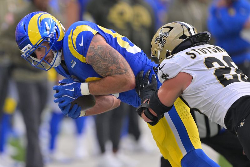 Nov 2, 2025; Inglewood, California, USA; Los Angeles Rams tight end Tyler Higbee (89) is pushed out of bounds by New Orleans Saints linebacker Danny Stutsman (28) after making a catch during the first half at SoFi Stadium. Mandatory Credit: Jayne Kamin-Oncea-Imagn Images