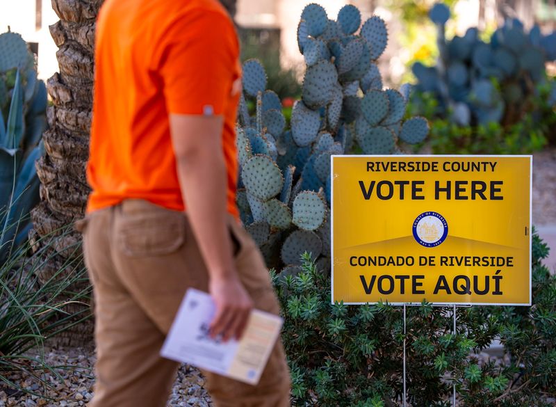 A voter walks in to drop off a ballot at a polling place at the city hall complex in La Quinta, Calif., Tuesday, Nov. 4, 2025.