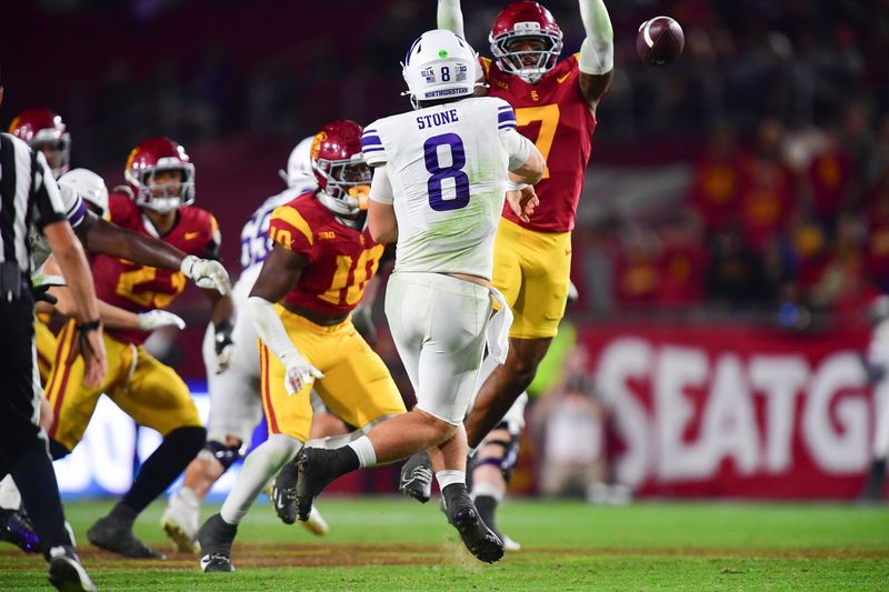 Nov 7, 2025; Los Angeles, California, USA; Northwestern Wildcats quarterback Preston Stone (8) throws under pressure from Southern California Trojans safety Kamari Ramsey (7) during the second half at the Los Angeles Memorial Coliseum. Mandatory Credit: Gary A. Vasquez-Imagn Images