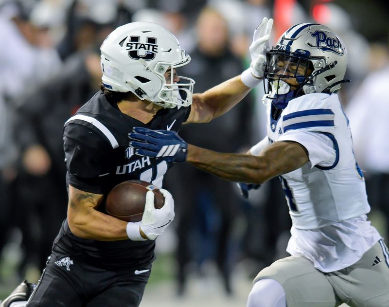 Utah State wide receiver Braden Pegan (11) tries to run past Nevada defensive back Edward Rhambo (4) during the first half Saturday, Nov. 8, 2025, in Logan.