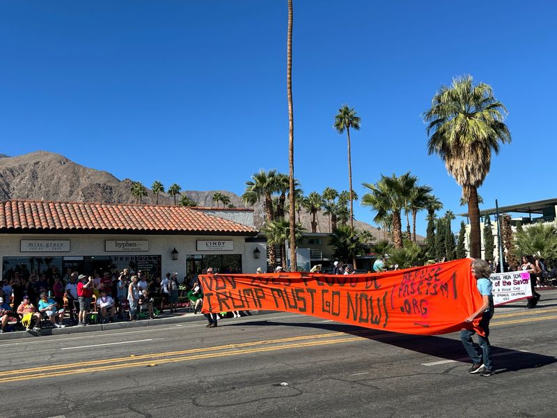 A couple attendees of the Palm Springs Pride Parade on Sunday, Nov. 9, joined the parade line with a handwritten banner criticizing President Donald Trump. The banner references a website for Refuse Fascism, a national organization.