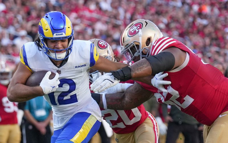 Nov 9, 2025; Santa Clara, California, USA; Los Angeles Rams wide receiver Puka Nacua (12) runs in for a touchdown past San Francisco 49ers defensive tackle Jordan Elliott (92) during the first quarter at Levi's Stadium. Mandatory Credit: Cary Edmondson-Imagn Images