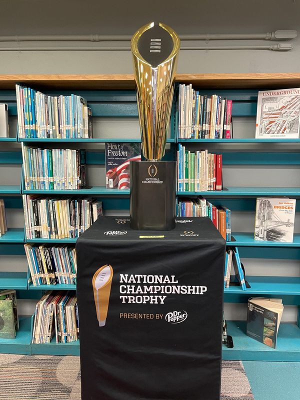 The College Football Playoff trophy is displayed at Miami's Brownsville Middle School for a news conference on April 10, 2025.