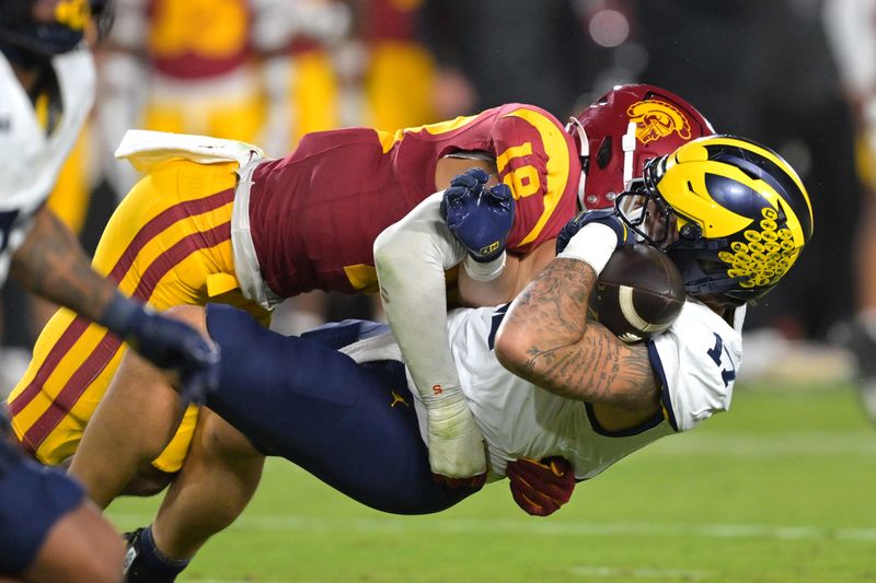 Oct 11, 2025; Los Angeles, California, USA; Michigan Wolverines tight end Marlin Klein (17) hangs on to the ball after a complete pass as he is stopped by USC Trojans linebacker Eric Gentry (18) in the second half at United Airlines Field at the Los Angeles Memorial Coliseum. Mandatory Credit: Jayne Kamin-Oncea-Imagn Images