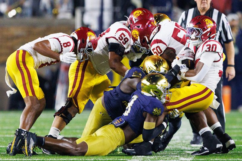 Notre Dame safety Adon Shuler (8) tacks Southern California running back King Miller (30) in the first half of a NCAA football at Notre Dame Stadium on Saturday, Oct. 18, 2025, in South Bend.