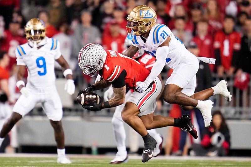Ohio State Buckeyes wide receiver Brandon Inniss (1) catches a ball in front of UCLA Bruins defensive back Cole Martin (21) during the NCAA football game at Ohio Stadium in Columbus on Nov. 15, 2025.