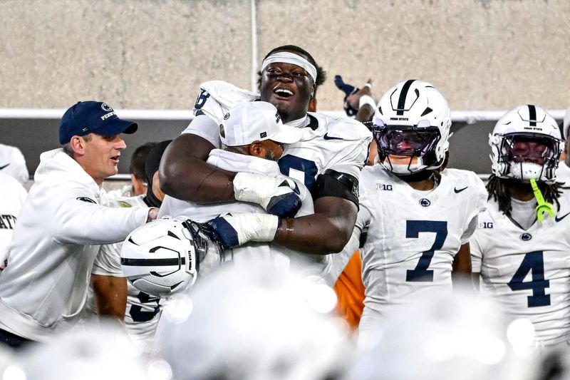 Penn State's Anthony Donkoh, center, hugs interim head coach Terry M. Smith as time runs short during the fourth quarter in the game against Michigan State on Saturday, Nov. 15, 2025, at Spartan Stadium in East Lansing.