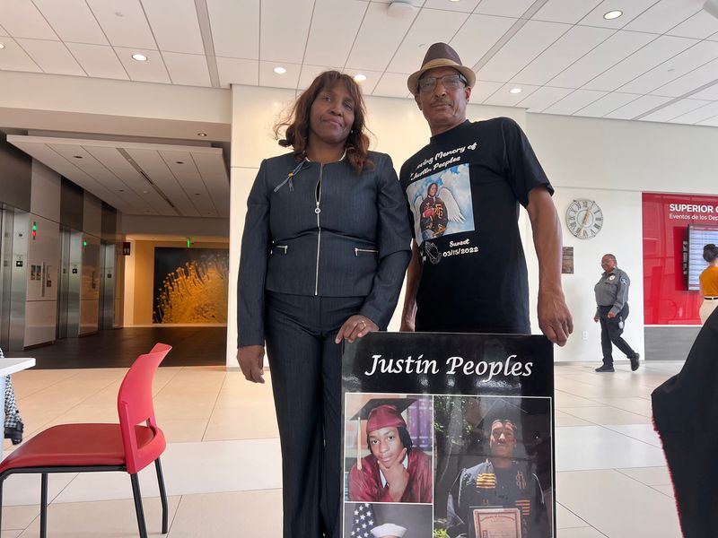 Gineene Everson and Maurice Peoples carry a sign into the sentencing hearing for Christina Garner and Jeremy Wayne Jones, who were convicted of murdering their son, Justin Peoples, at the San Joaquin County Superior Court in downtown Stockton on Nov. 17, 2025.