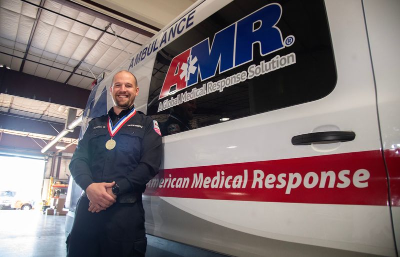 American Medical Response paramedic Dustin Wilson is a recipient of the American Ambulance Association’s Star of Life award for ambulance professionals who have gone above and beyond the call of duty in service to their communities or the EMS profession. Wilson was a part of an AMR crew that responded to an unresponsive person hanging from a bridge tangle in a rope. The person appeared to be rappelling from the bridge to recover items that fallen into the water below. With other rescue personnel yet to arrive. Wilson climbed over the guardrail to reach the patient. His action allow his team to retrieve the patient to safety and start CPR.