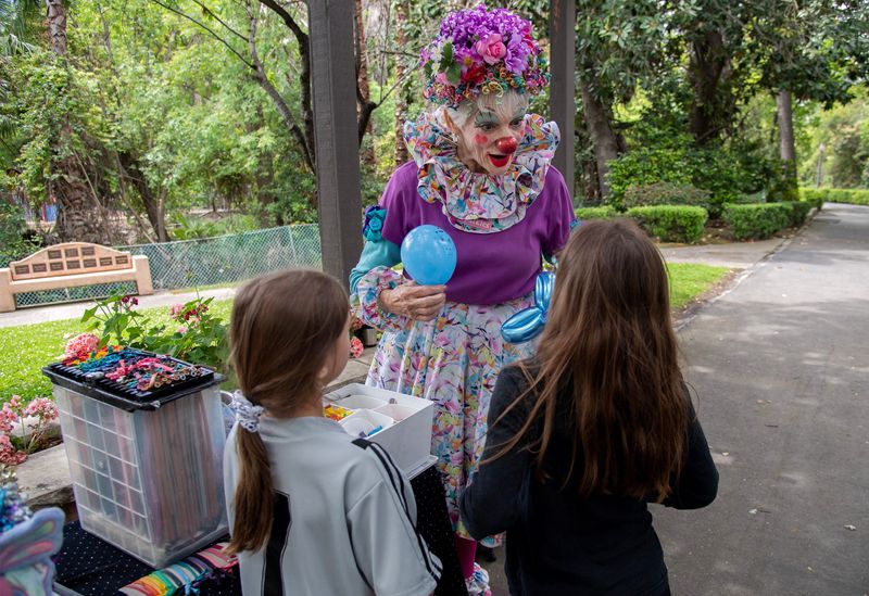 Sparkles the Clown makes balloon animals for sisters Madelyn, left, and Annabelle Regalia during opening day at Pixie Woods on May 3, 2025.